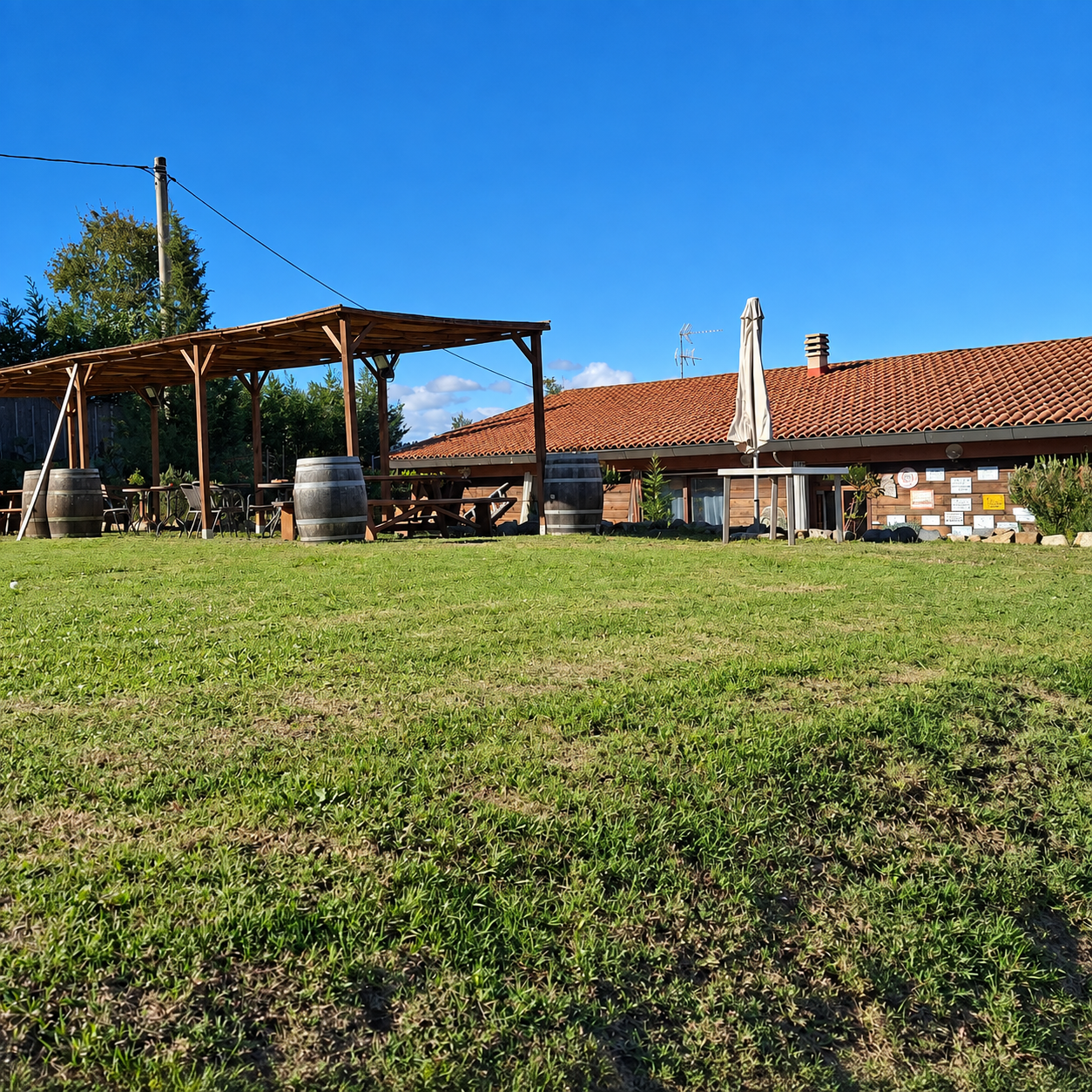Giardino del Ranch con pergolato, casale in pietra e prato